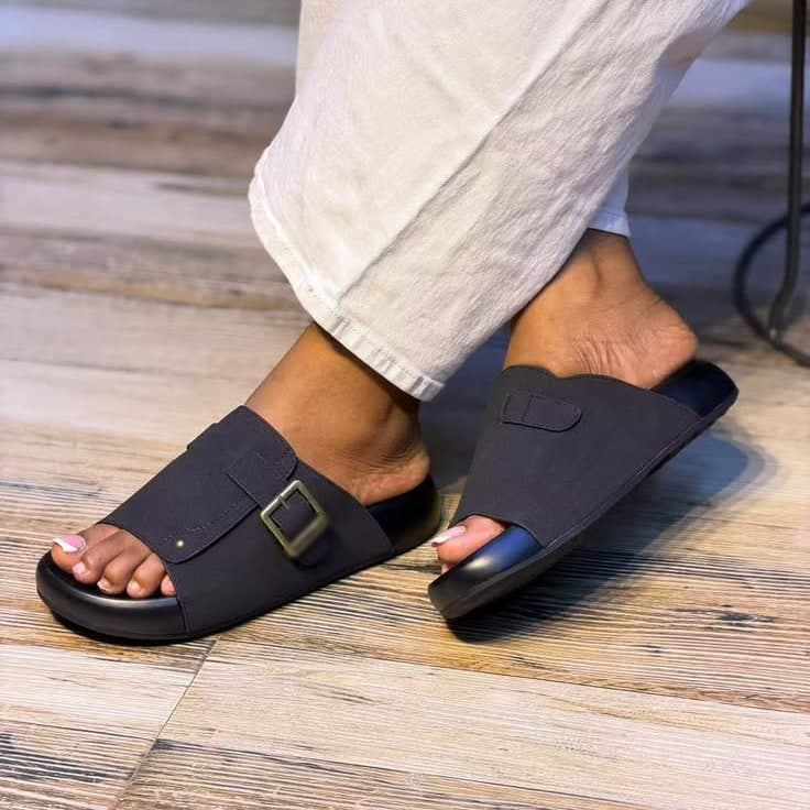 Black buckle slides worn with white linen trousers